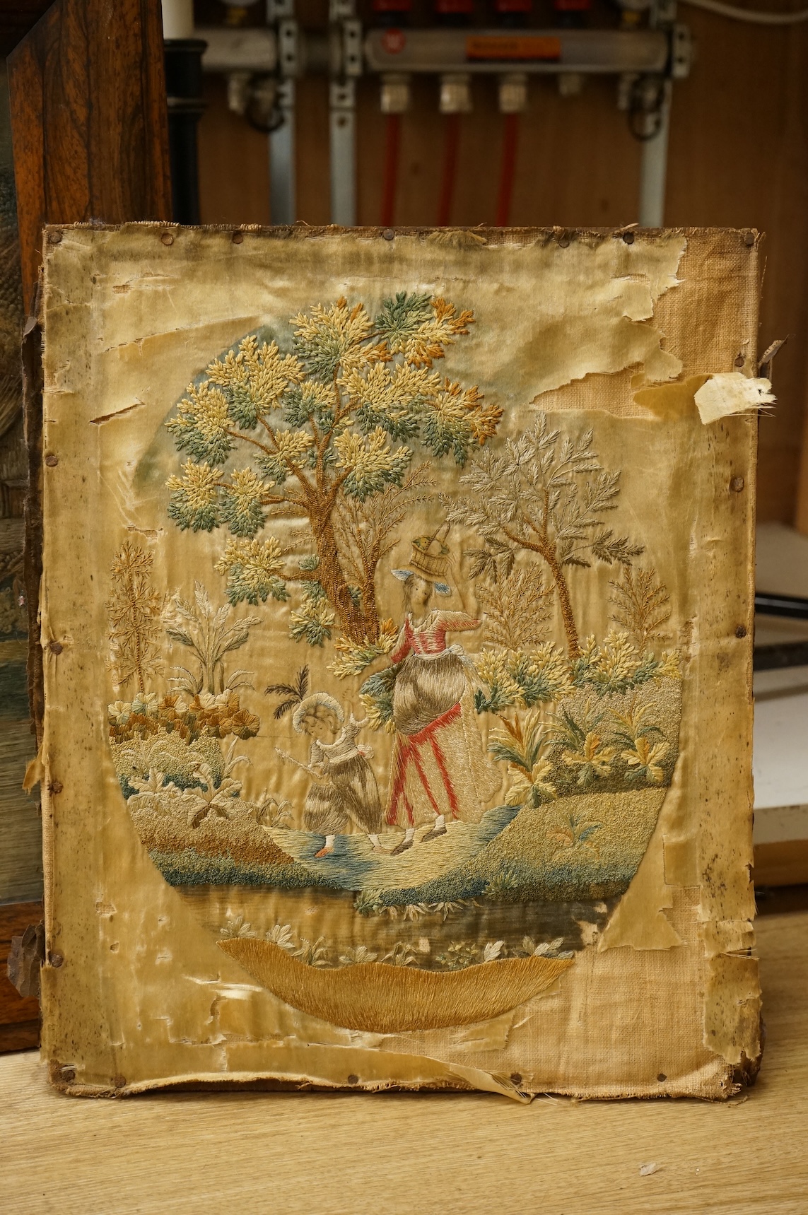 Two early 19th century embroidered silk tapestries depicting figures in landscapes, one framed, largest 52cm high